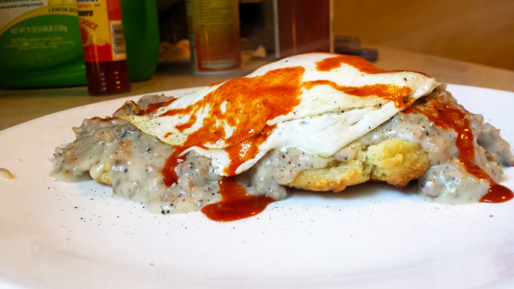Biscuits and gravy with fried egg and hot sauce