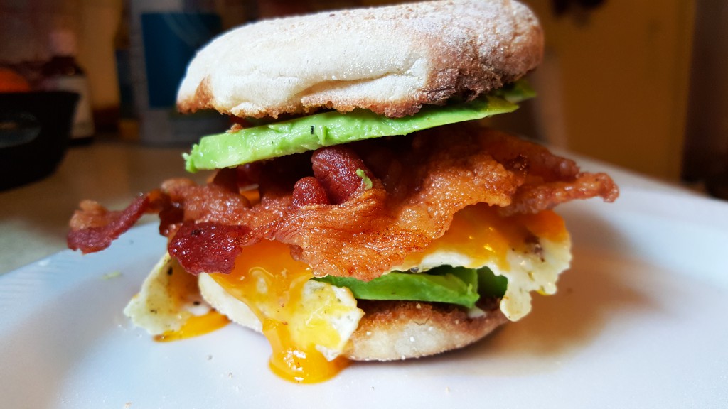 bacon, egg, and cheddar with avocado on English muffin