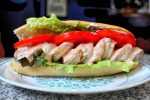 Shrimp roll with lettuce, tomato, aioli, and cocktail sauce