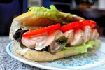 Shrimp roll with lettuce, tomato, aioli, and cocktail sauce