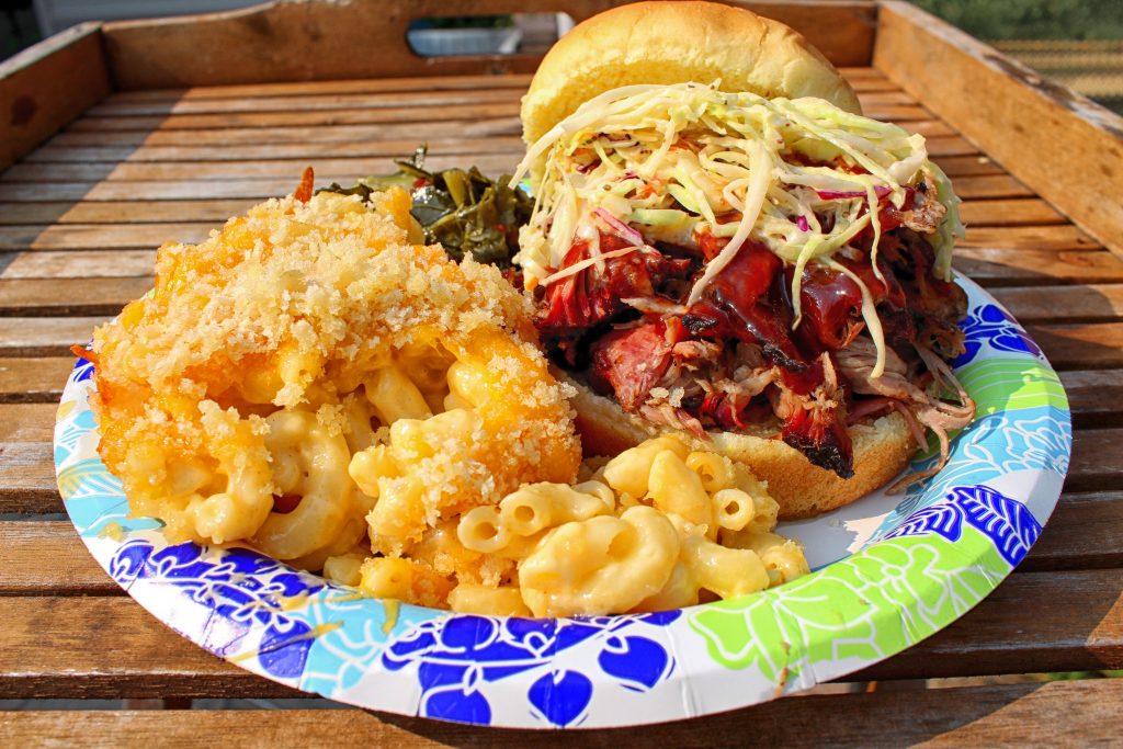 Pulled pork sandwich with coleslaw, mac & cheese, greens